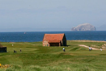 Historic Dunbar Golf Club in East Lothian, Scotland, features 14 holes that play alongside the sea, in view of the Bass Rock offshore.
