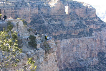Tourists stare down at the Grand Canyon from a ledge. No doubt at least one's thinking about golf.