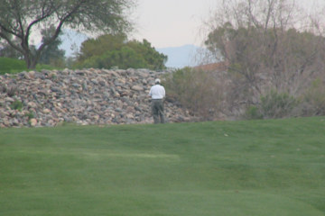 A golfer confronts the rock wall on No. 6, too close for comfort.
